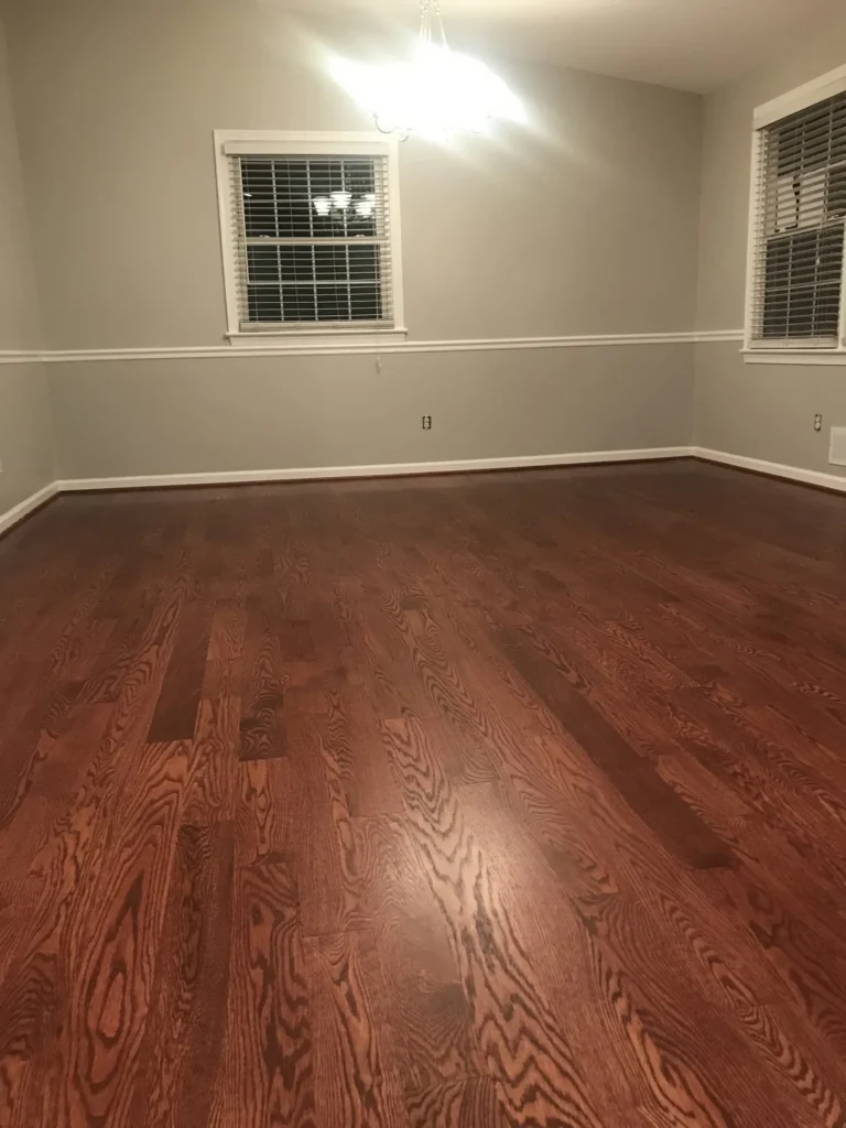 Finished room with stained hardwood floor, chair rail and a window