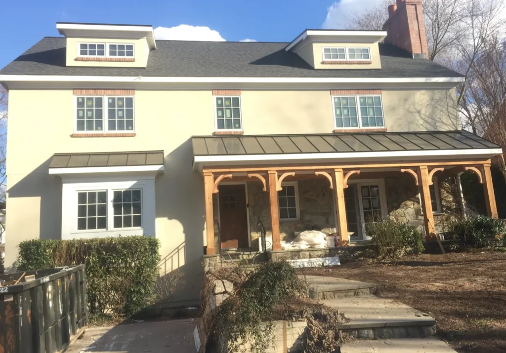 Two-story home with a new timber-post front porch and a standing-seam metal roof