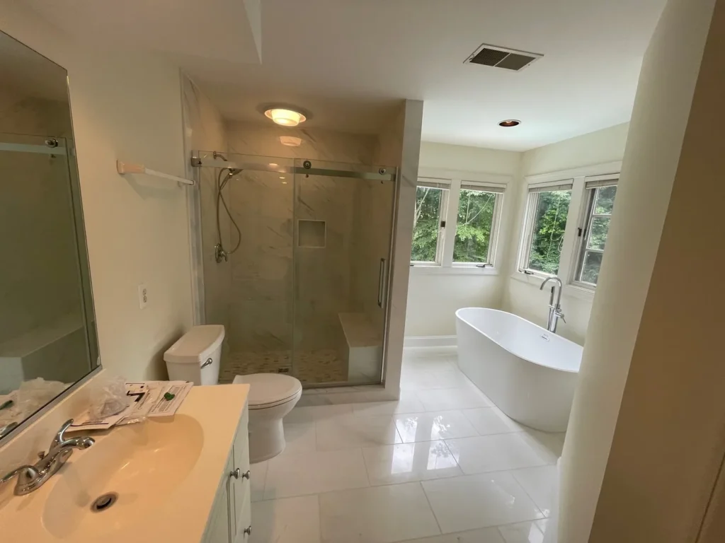 Bathroom remodeling project: primary bathroom with a glass shower, freestanding tub and white tile floor