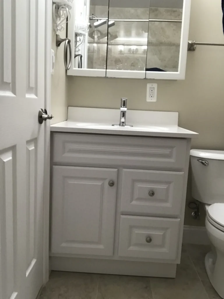 Bathroom with a raised-panel vanity, white top and a new toilet