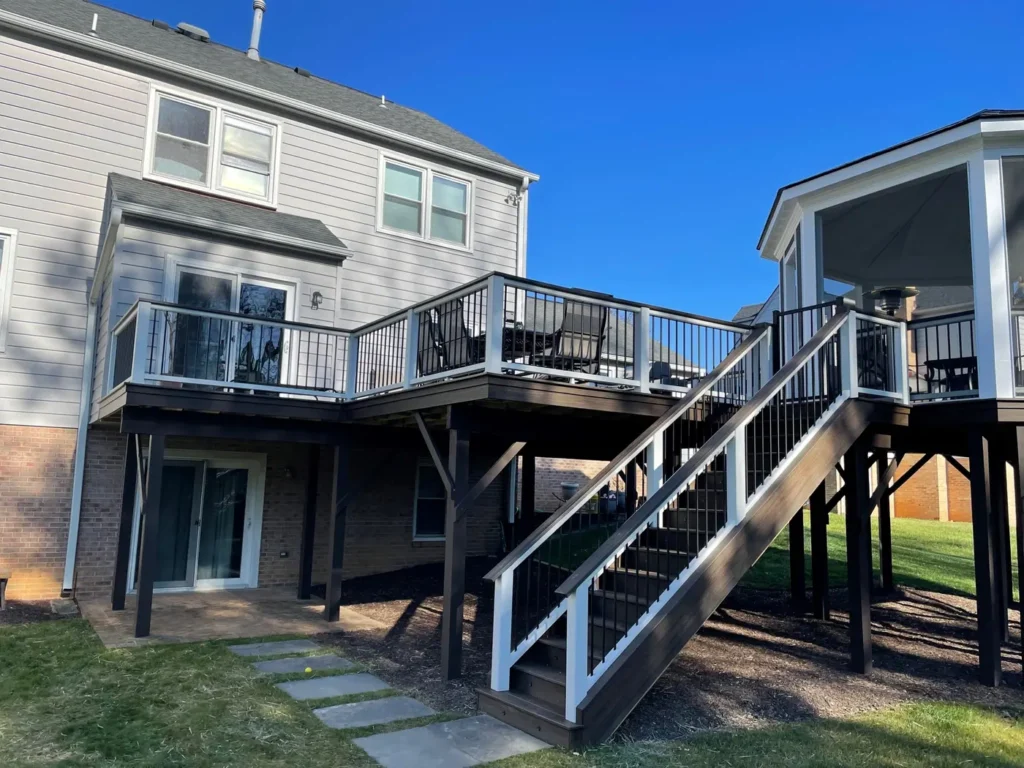 Two-level deck with white railings, a wide stair and a screened octagonal gazebo behind a gray house