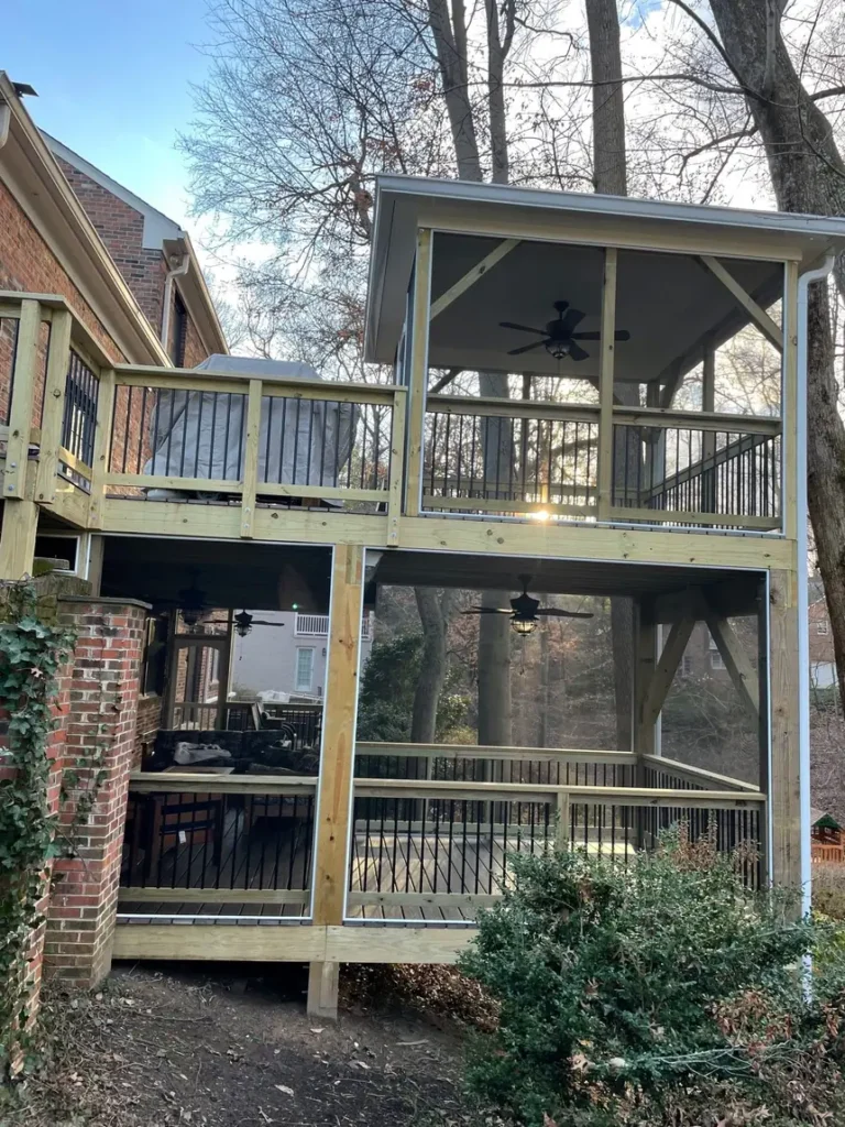 Tall screened porch with a deck on top, framed in pressure-treated lumber on a wooded lot