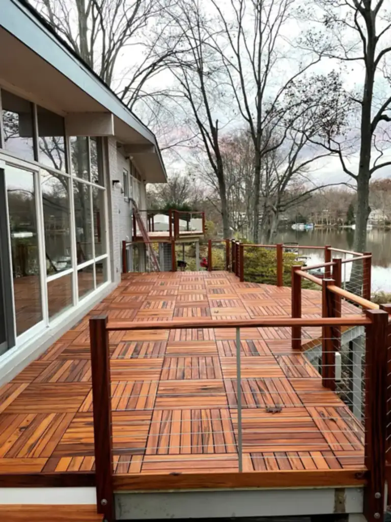 Long hardwood deck with cable railing beside a lake, built by Reyes Construction Group, a deck builder in Fairfax, VA