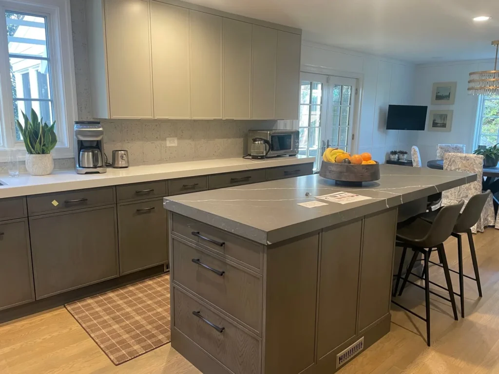 Kitchen remodel with dark gray cabinets and a large island with bar seating