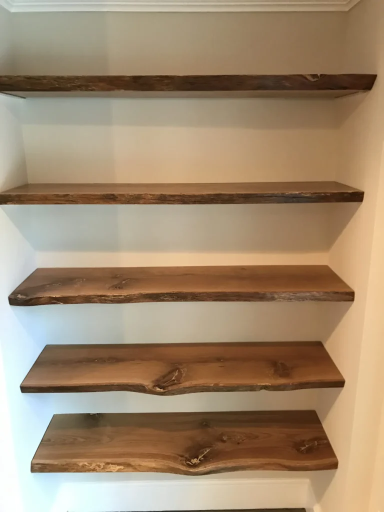 Close-up of live-edge walnut shelves in a wall alcove