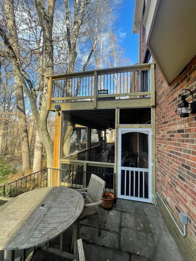 Two-level screened porch with a deck above, attached to a brick home